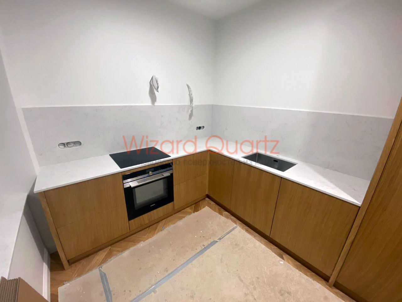 Г-образная столешница из кварцевого камня со стеновой панелью белого цвета